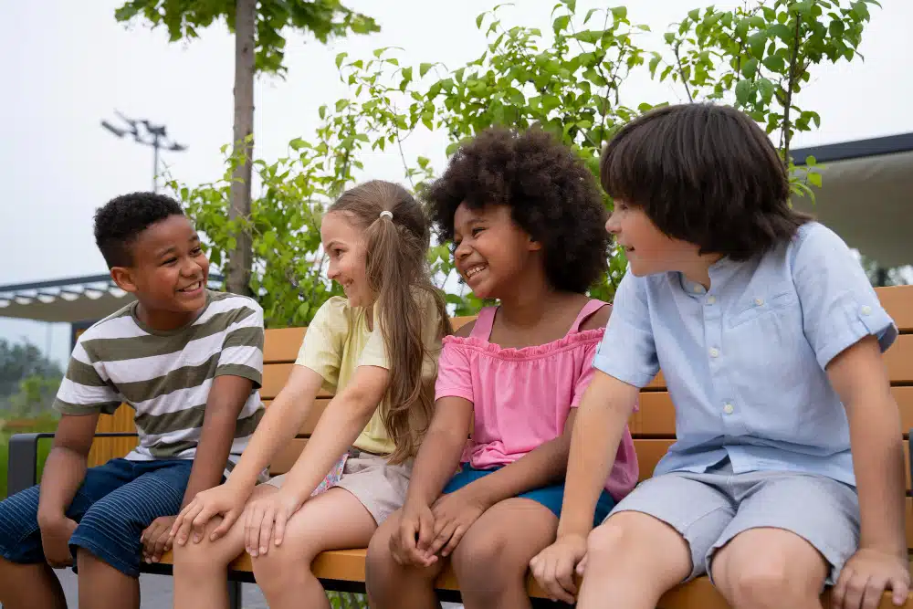 a group of children sitting on a bench- how to help your kids make friends